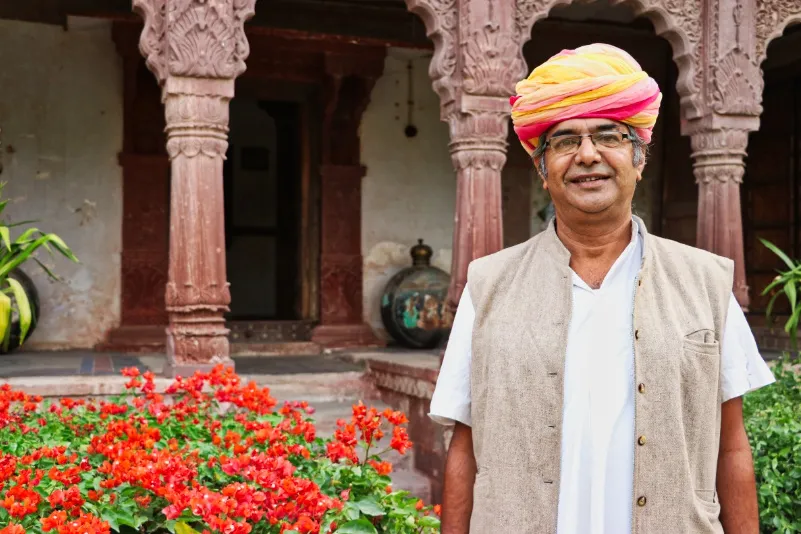 Lokale man die voor een Rajasthan homestay staat - LIMITED RIGHTS DAISY.