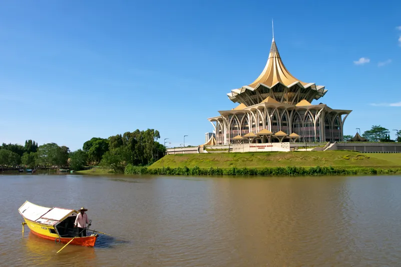 Maleisisch Borneo - bootje in het water met een gebouw op de achtergrond in Kuching.