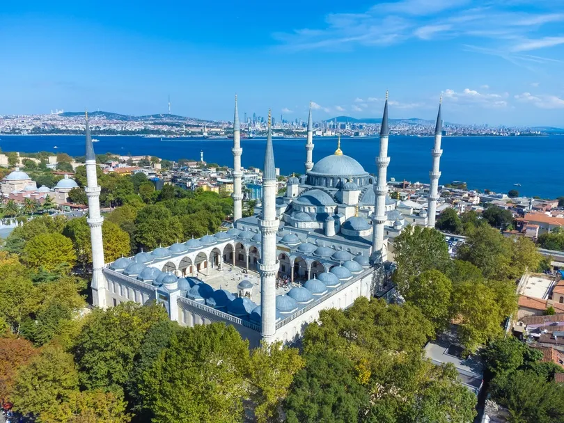 Luchtfoto van de Blauwe Moskee in Istanbul, omringd door groen bomen en de stad en de zee op de achtergrond.