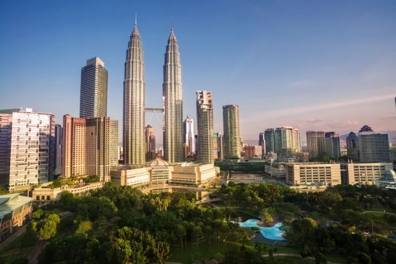 Skyline van Kuala Lumpur met hoge gebouwen en een groen park. 