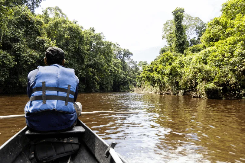 Man op een bootje dat vaart over de Taman Negara rivier.