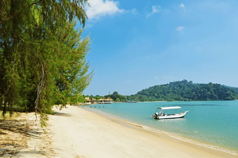 Strand van Pangkor met herder blauw water en een boot. 