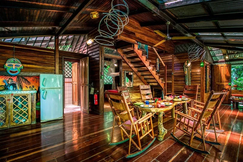 Houten huisje met eettafel en keukentje.