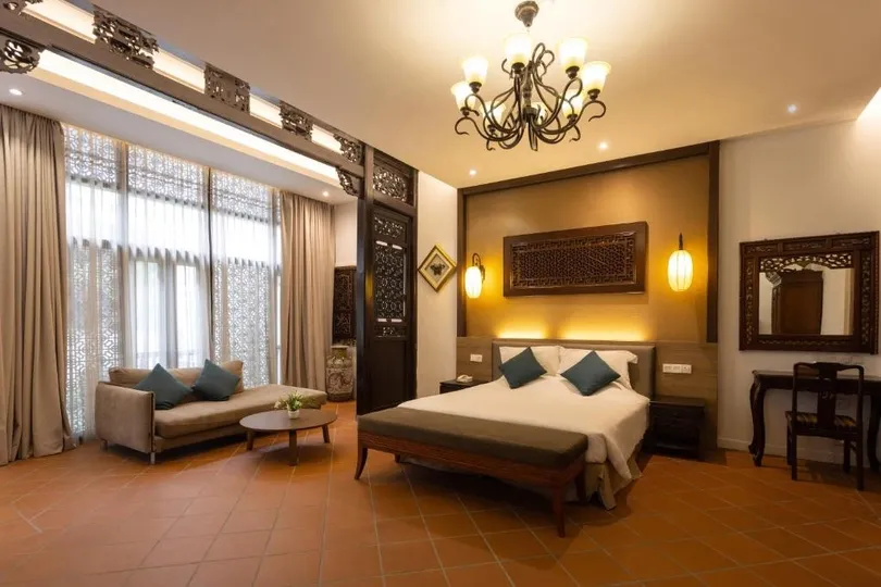 Ruime hotelkamer met bed en bank.