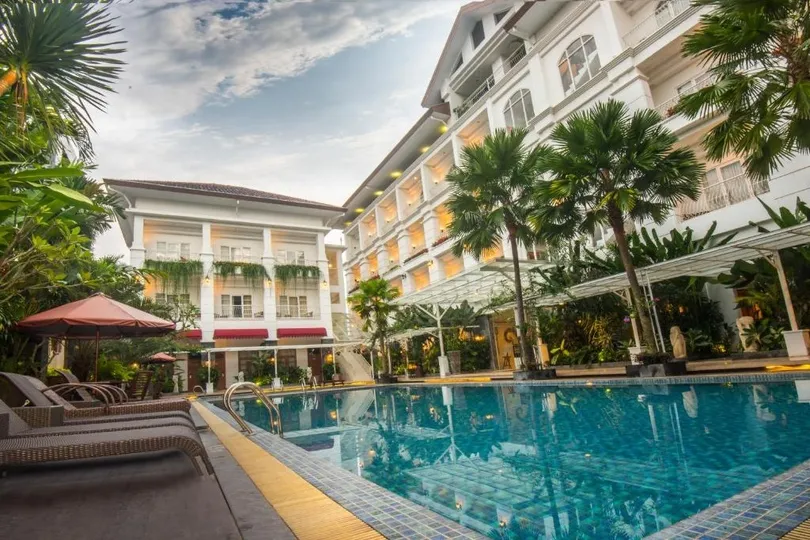Hotel met zwembad en palmbomen.