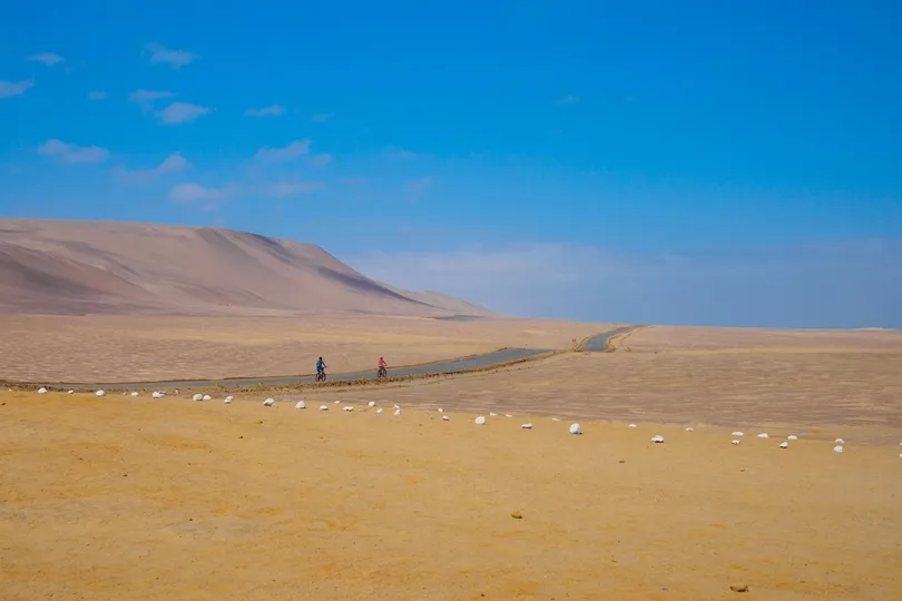 Twee fietsers in de woestijn van Paracas.
