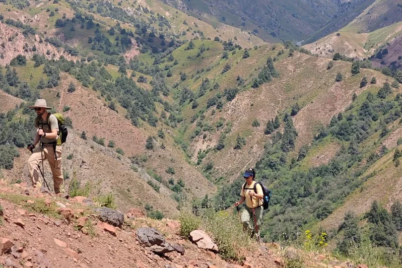 Twee wandelaars lopen door de bergen in Oezbekistan.