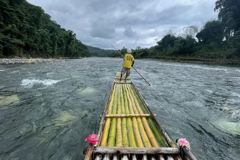 Een bamboevlot vaart over een rivier door Jamaica.