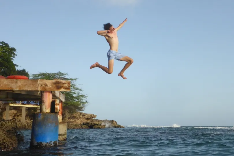 Springende reiziger boven een meer in Jamaica.