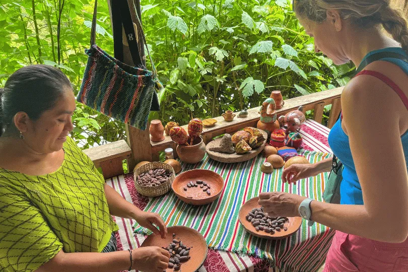 Een reiziger leert van een inwoner hoe cacaobonen worden verwerkt tijdens een activiteit in Guatemala.