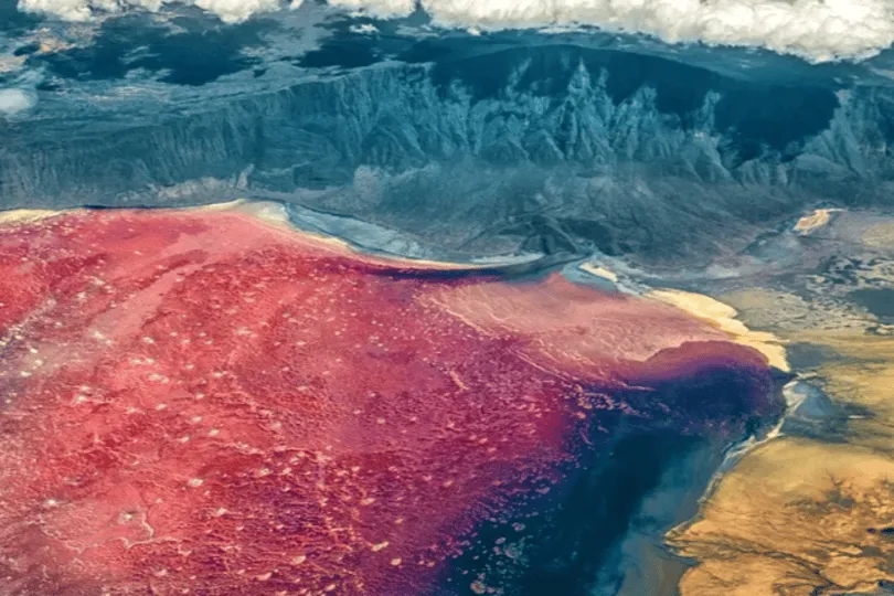 Meer met roze en blauw in berggebied.
