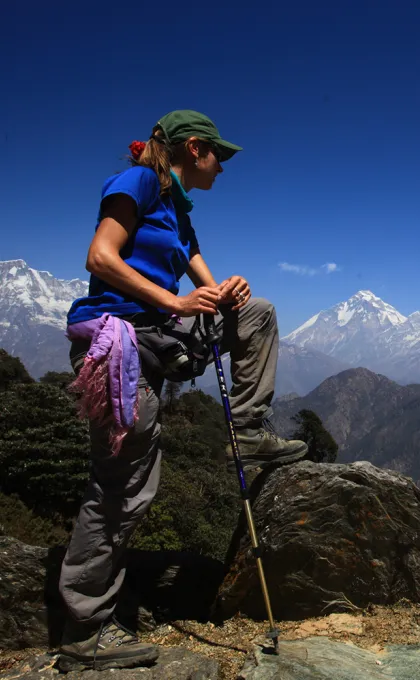 vrouw tijdens trektocht met uitzicht Himalaya