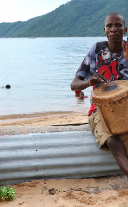 Mannen met trommels zittend bij lake Malawi