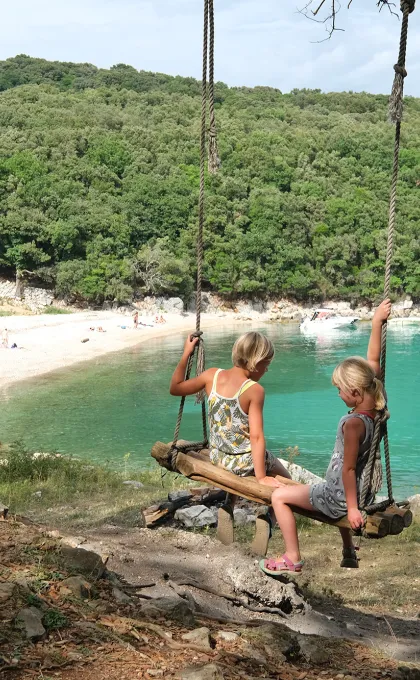 Zomervakantie 2025 kinderen op schommel.