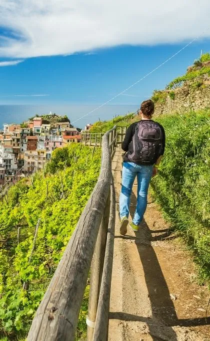 Man wandelt langs de kust van de Cinque Terre.