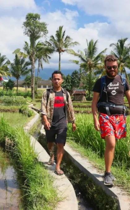 Reiziger met local tijdens een wandeltocht op Lombok, Indonesië.