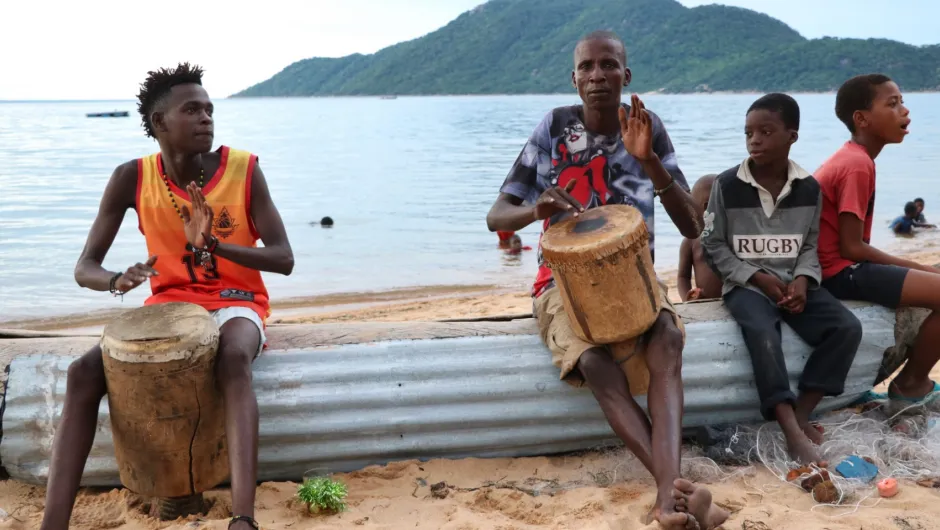 Mannen zitten aan Lake Malawi met trommels 