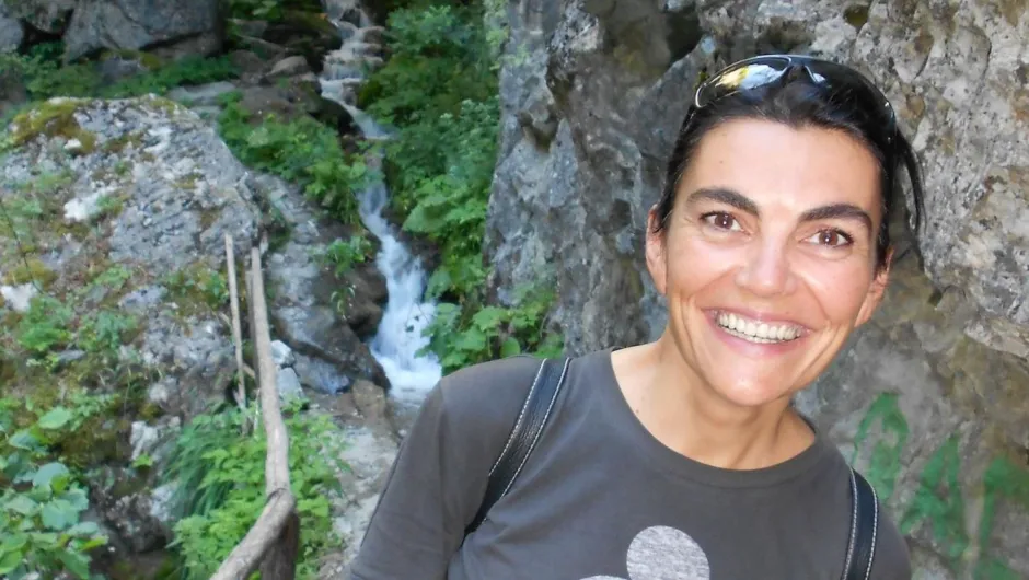 Een foto van een glimlachende vrouw met zwart haar. 