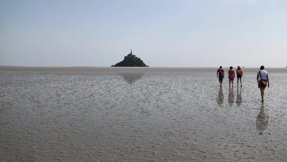 Wadlopers met de Mont Saint-Michel in de verte.