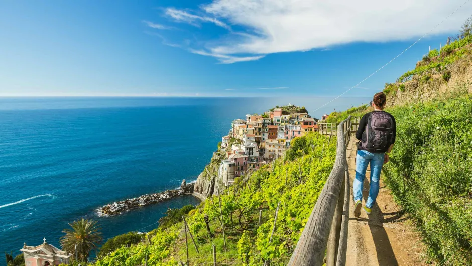 Man wandelt langs de kust van de Cinque Terre.