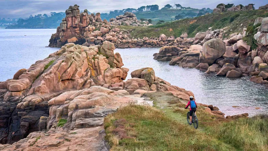 Fietser door de rode granietkust van Bretagne.