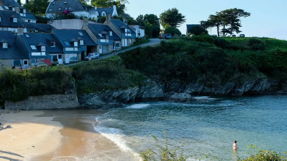 Mensen zwemmen aan een strand in Bretagne.