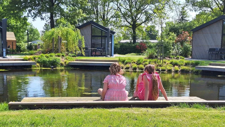 Twee meiden zitten buiten op het gras.