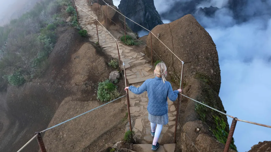 Kind wandelt over een bergpad boven de wolken op Madeira