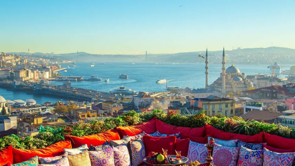 Uitzicht van dakterras met rode bank over Istanbul op de haven en moskee.
