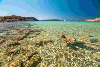 Vrouw snorkelt in zee in Griekenland.