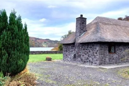 Een stenen cottage naast een boom in Schotland.
