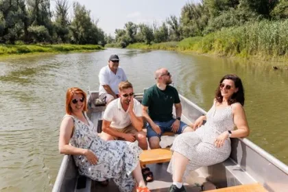 3 mannen en 2 vrouwen hebben een boottochtje op een rivier. 