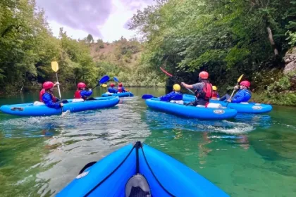 5 b;auwe kayak bootje die aan het varen zijn.