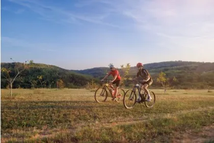 2 mannen die op het groene platteland fietsen. 