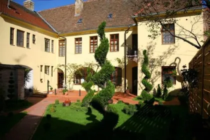 Een geel gebouw met twisting groene plant struiken.