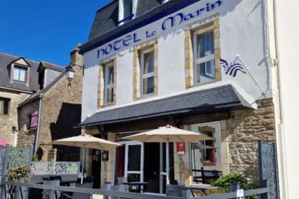 Vooraanzicht van hotel Le Marin in Bretagne, Auray, met een klein terrasje en de vlag van Bretagne.