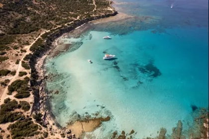 Baai met helder blauw water een boot.