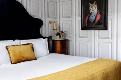 Hotelkamer met schilderij en geel beddengoed.