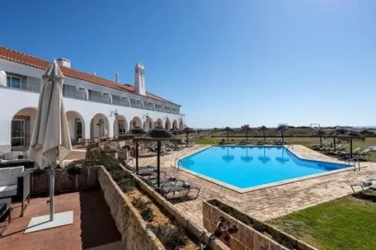 Hotel met zwembad, ligbedden en parasols.