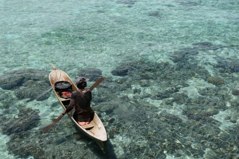 Iemand zit op een boot in het water.