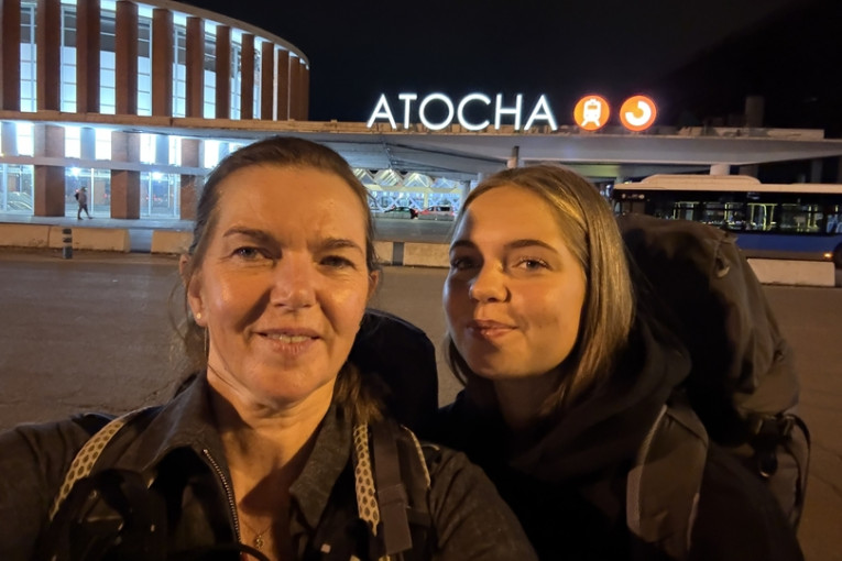 Selfie van twee mensen voor het treinstation.
