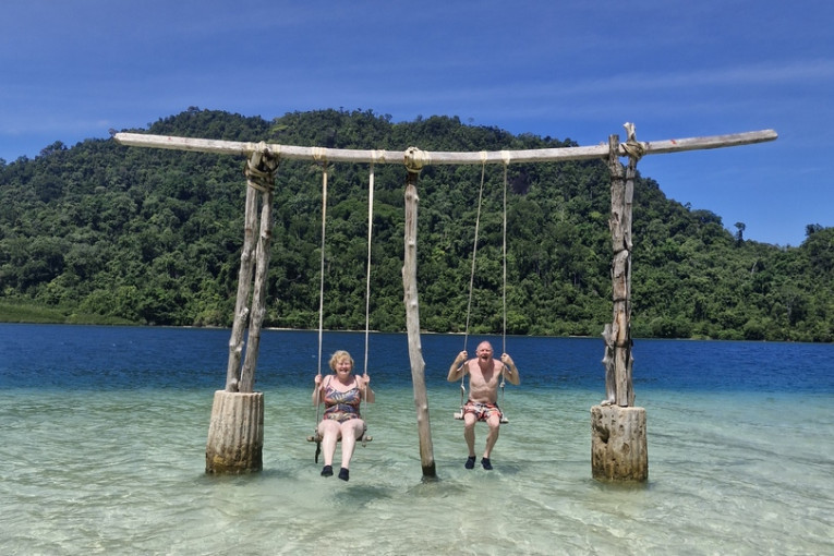 Twee mensen zijn aan het schommelen in het water van Indonesië.