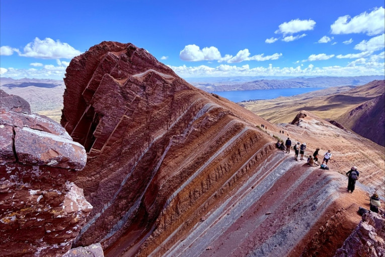 Mensen staan op de Palccoyo Rainbow Mountain in Peru.
