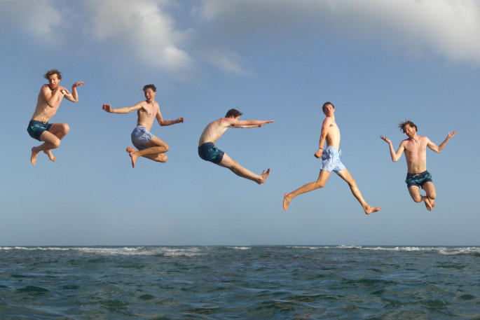 Vrolijke en springende reizigers in Jamaica.