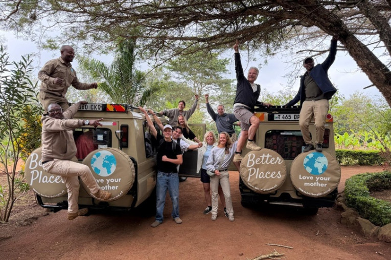 Blije reizigers met hun gidsen en safariwagens in Tanzania.