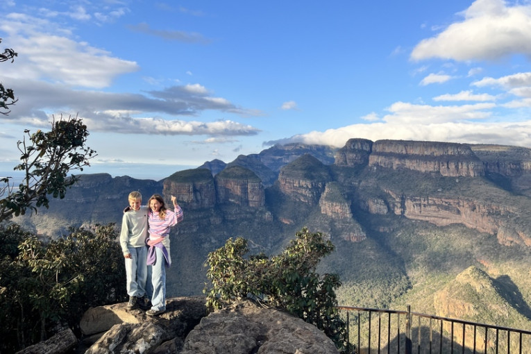 Twee kinderen staan op een steen in de natuur van Zuid-Afrika.