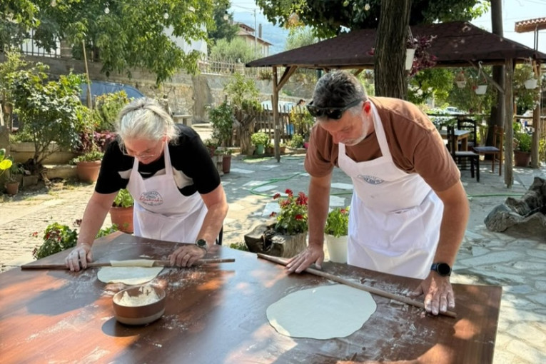 Twee mensen volgen een kookworkshop in Albanië.