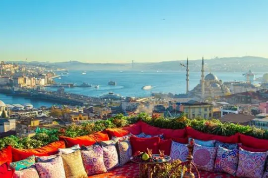 Uitzicht vanuit een dakterras met rode bank over Istanbul haven en moskee.