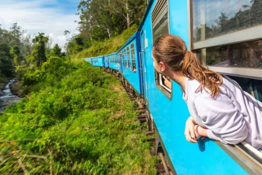 Een meisje kijkt uit het raam van de trein van Kandy naar Ella.